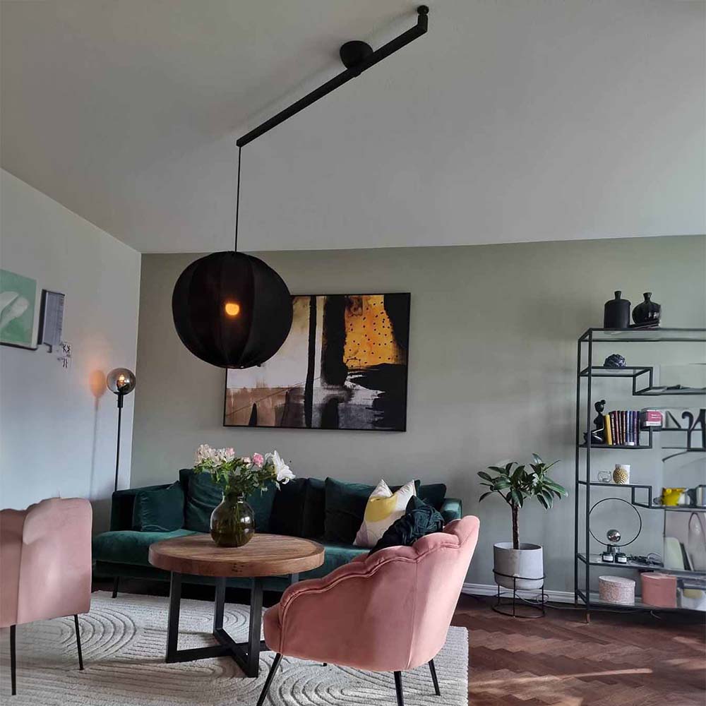 Designrum med en sort forlængerarm, der ændrer placeringen af en sort lampeskærm